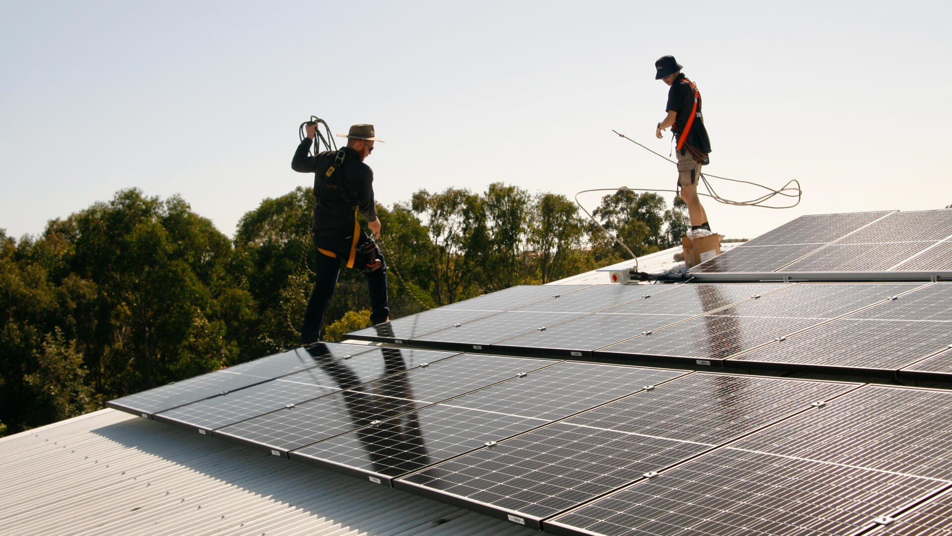 Two solar installers working on the solar system in the roof of a Kawana property.