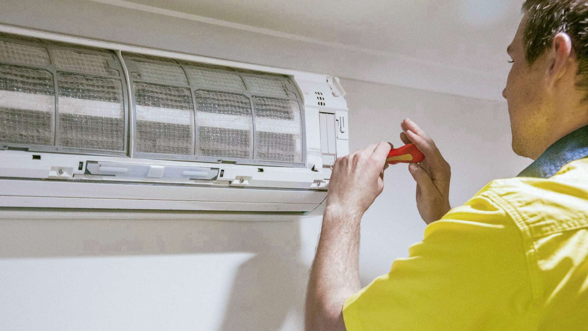 A man performing air conditioning installation in a room on the Sunshine Coast.