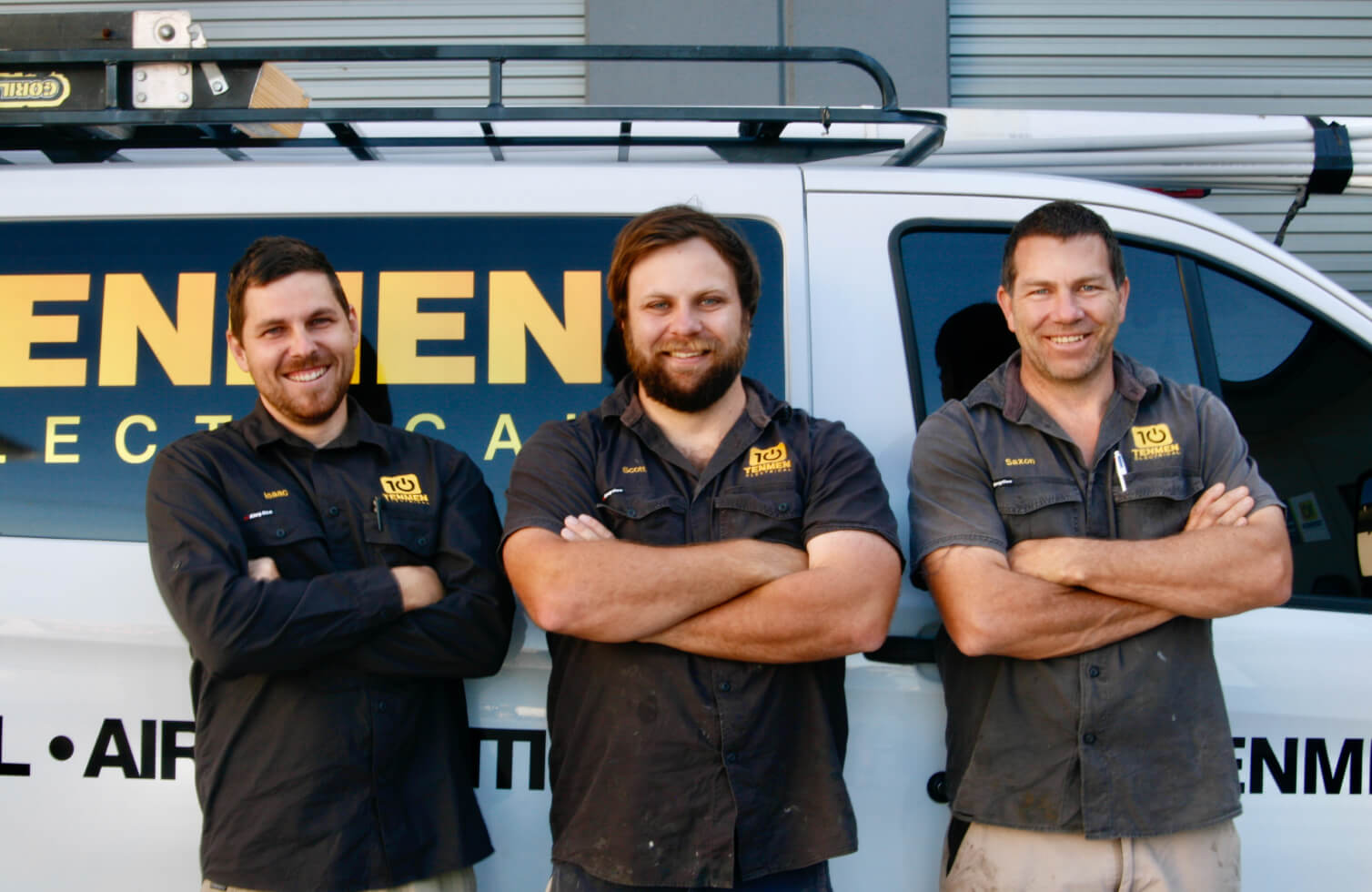 The leading team from Tenmen Electrical standing in front of the working van posing with their arms crossed.