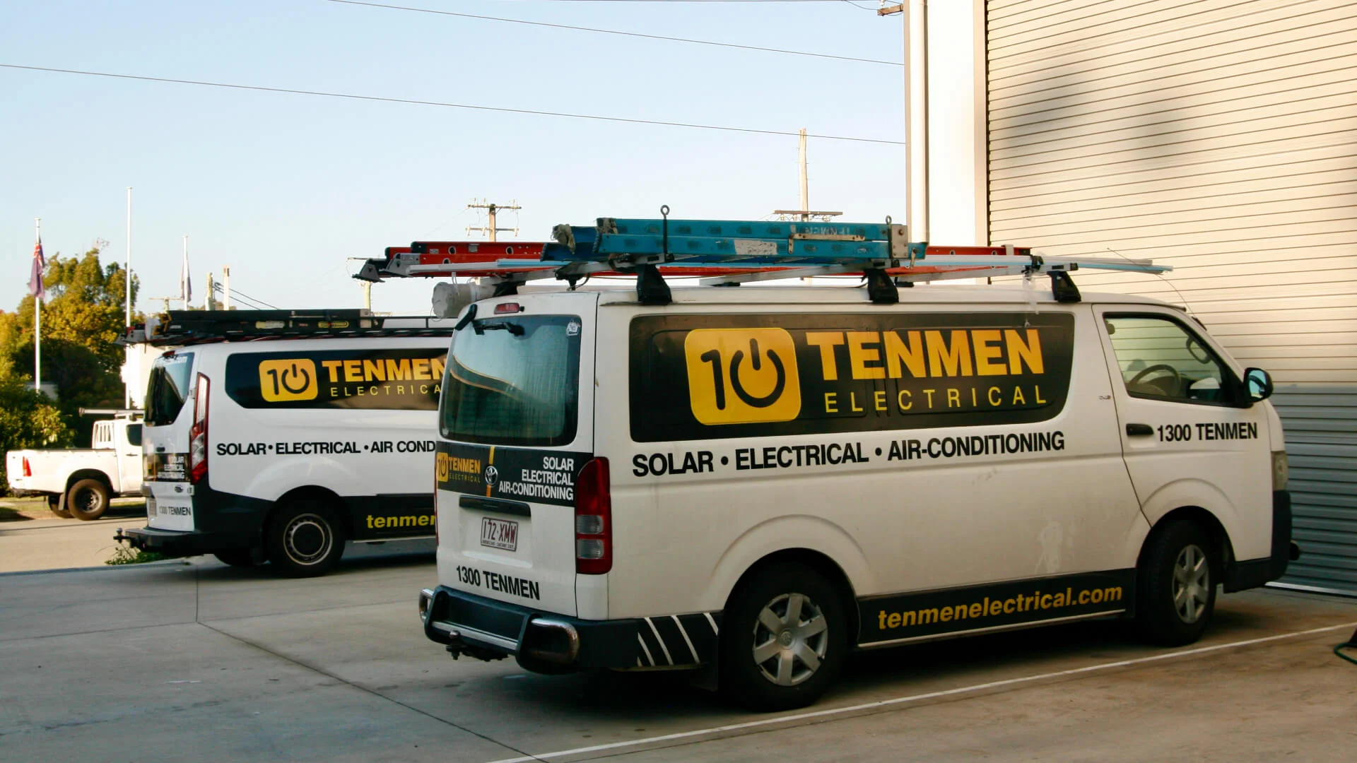 Two Tenmen Electrical vans parked in front of their building on the Sunshine Coast