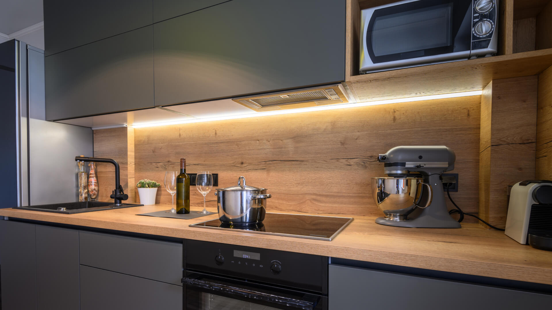 A kitchen with a stove and microwave undergoing electrical renovations on the Sunshine Coast.