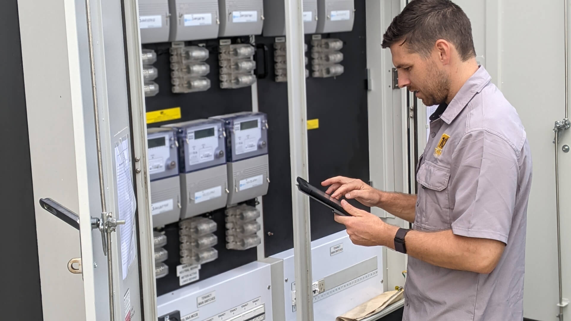 A man conducting an Energy Audit on the Sunshine Coast using a device to check an electrical panel.