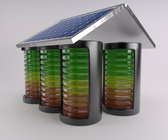 Three cylindrical batteries of varying charge levels under a roof with solar panels.