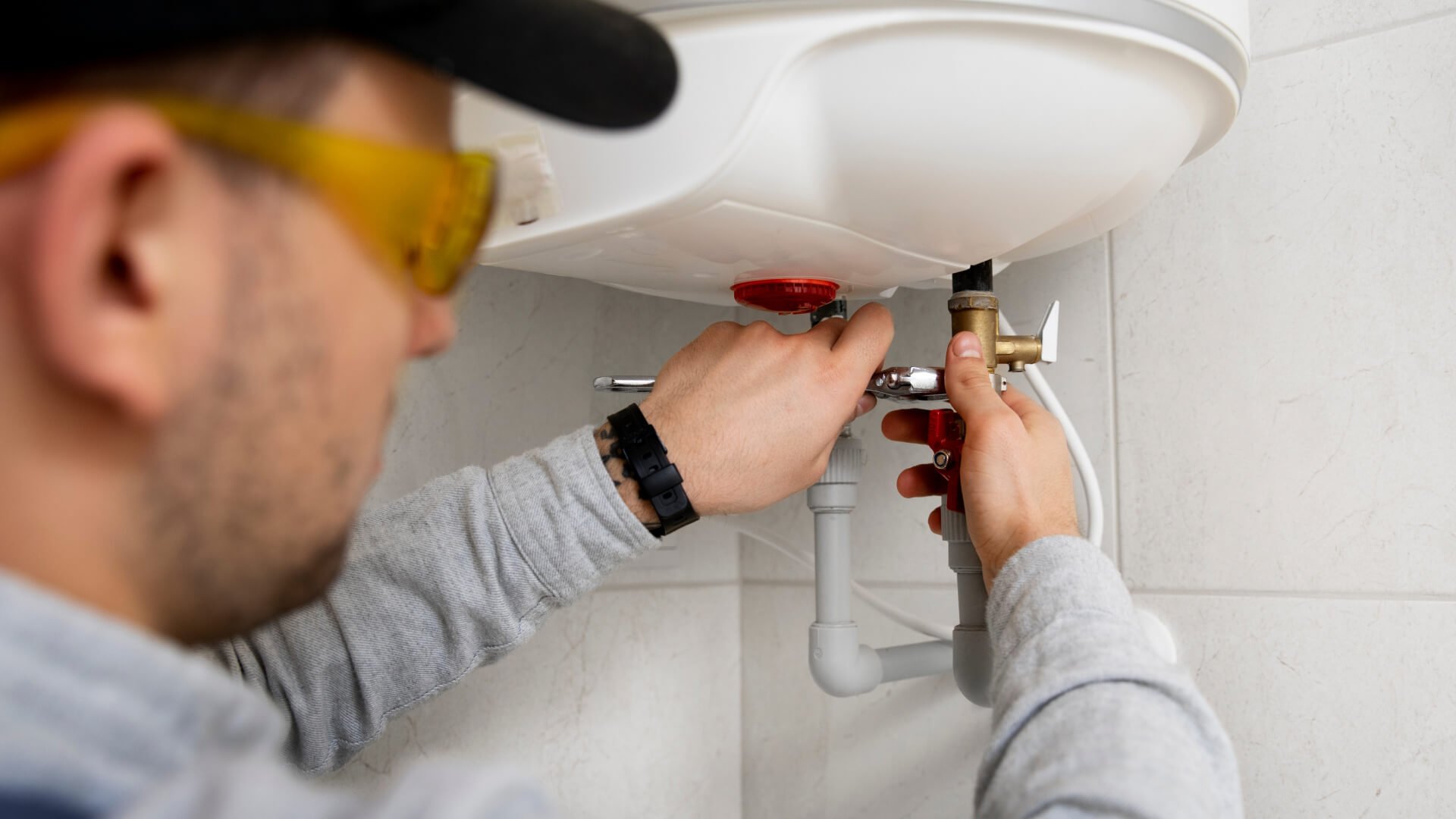 A plumber installing a hot water system in a bathroom on the Sunshine Coast.