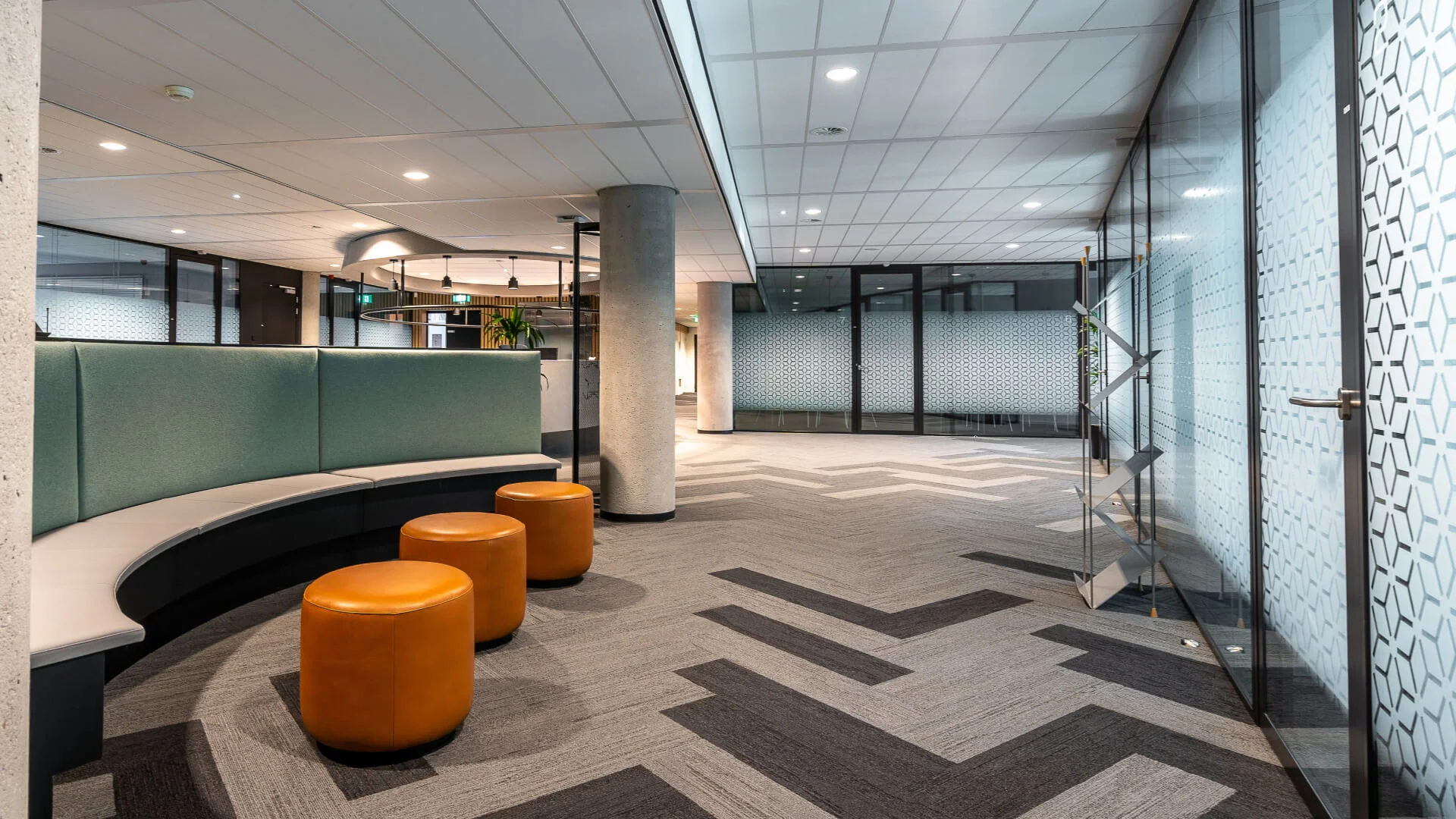 A hallway with orange stools and a glass wall, where a commercial electrician on the Sunshine Coast has performed expert installation and maintenance.