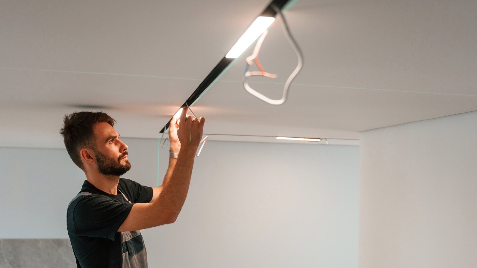 A man is performing a lighting installation in a room on the Sunshine Coast.