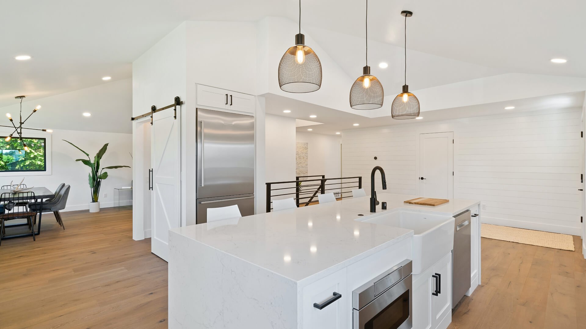 A modern kitchen with white cabinets and a large island, perfect for homeowners looking to hire residential electricians in the sunshine coast area.