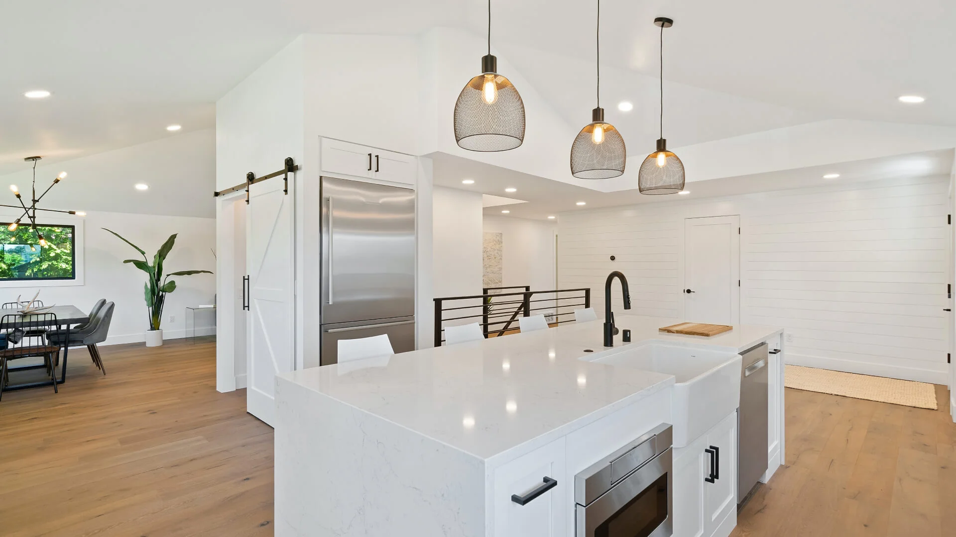 A modern kitchen with white cabinets and a large island, perfect for homeowners looking to hire residential electricians in the sunshine coast area.