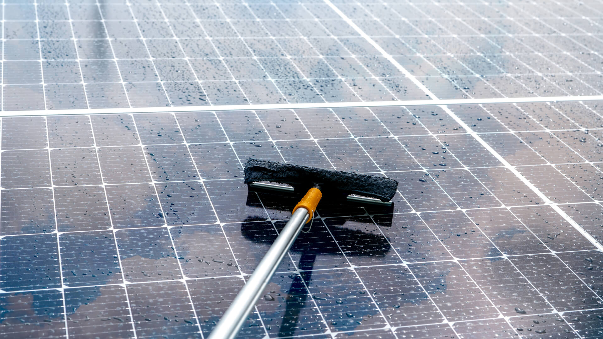 Cleaning a solar panel with a broom on the Sunshine Coast Keywords: solar panel cleaning