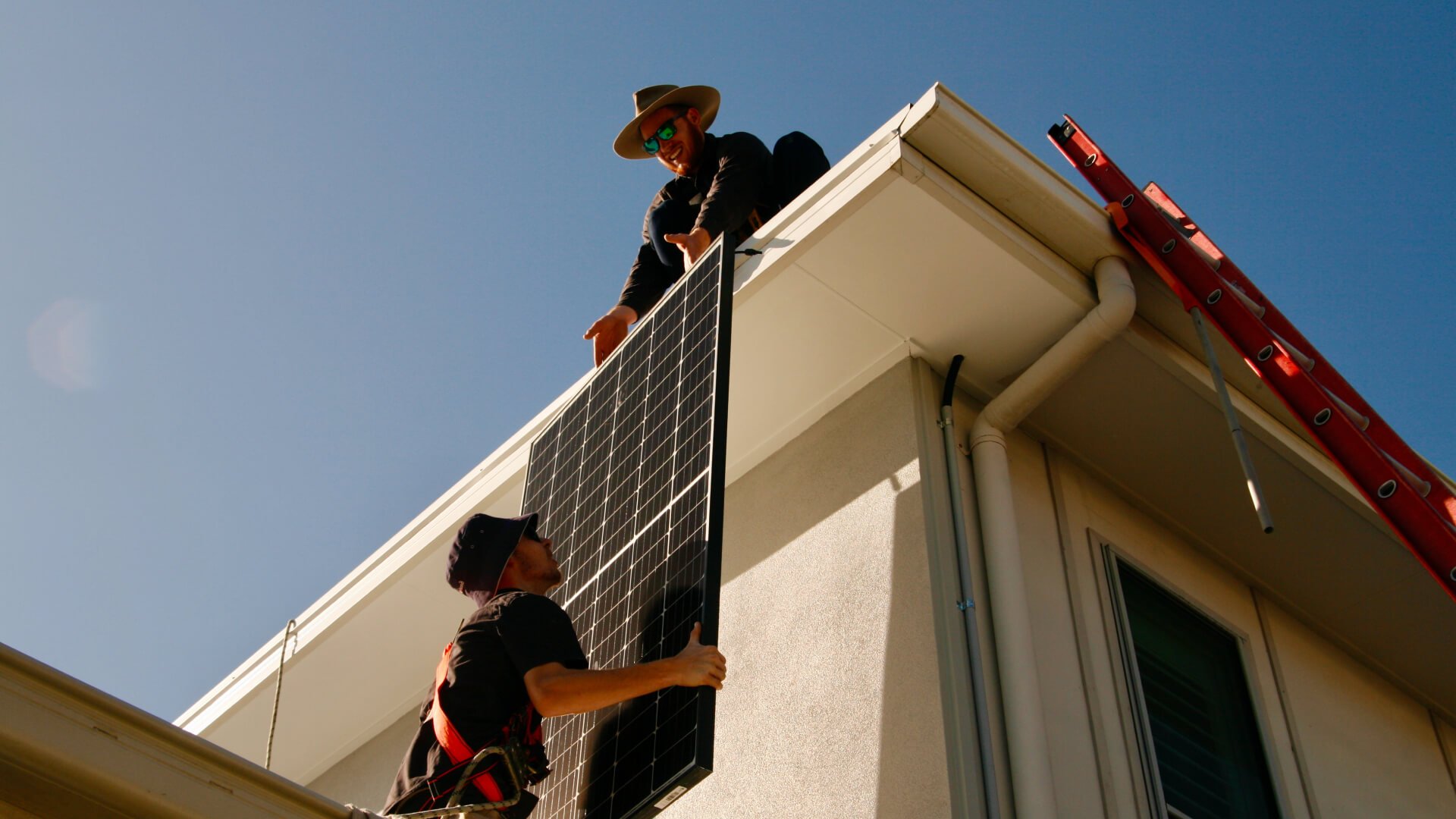 Two solar installers working on solar a installation on a roof of a Sunshine Coast house.