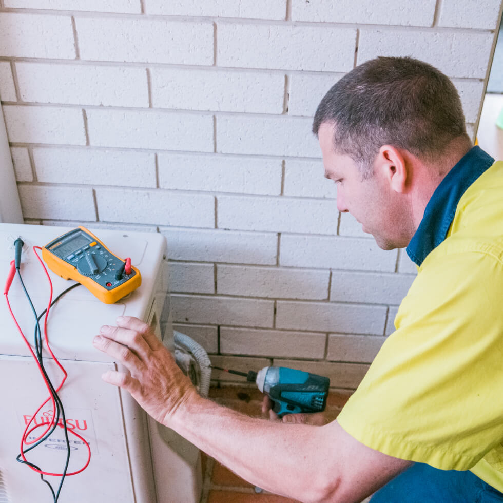 A technician is working on an air conditioning unit in Buderim.
