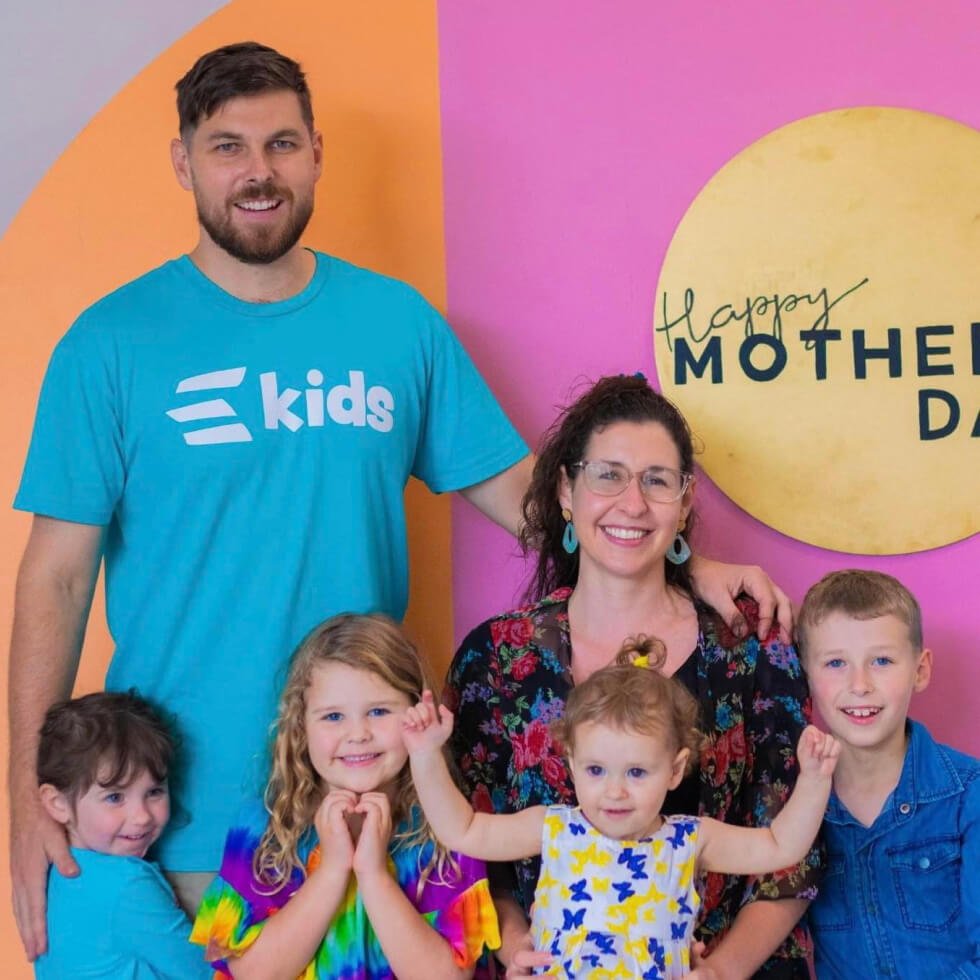 A Tenmen Electrical family posing in front of a mother's day sign.