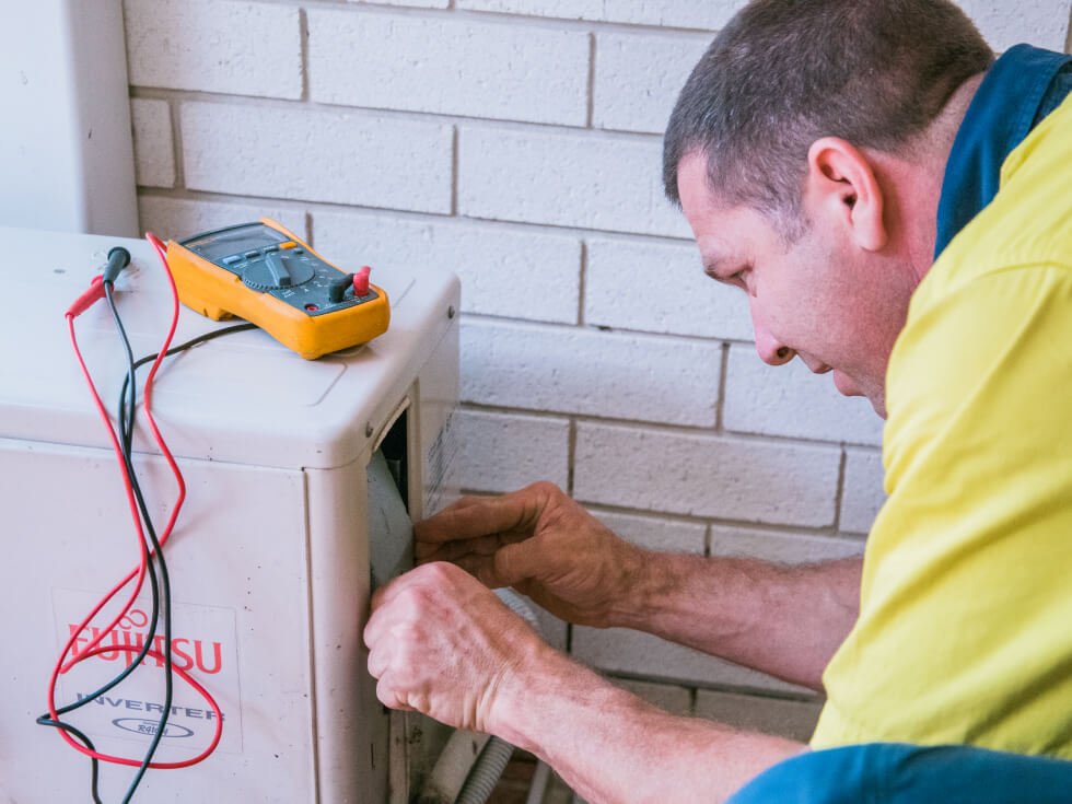 Tenmen electrician is working on an air conditioner.