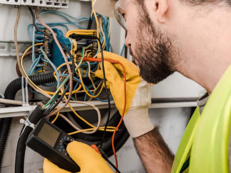 A man is working on an electrical system.