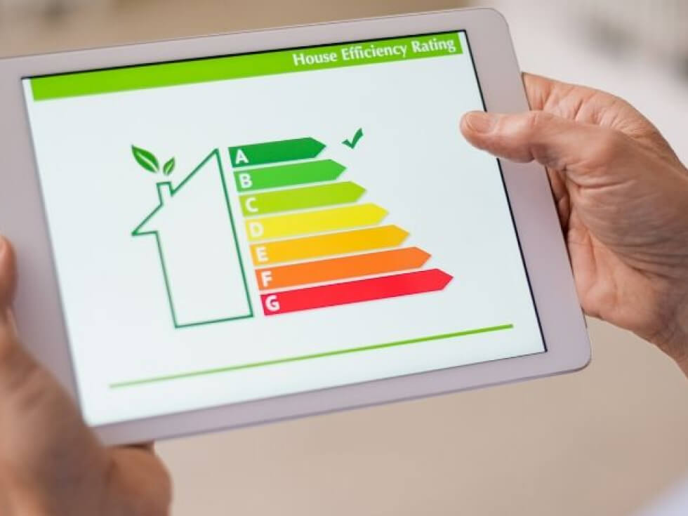 A person holding an ipad with an energy efficiency chart on it.